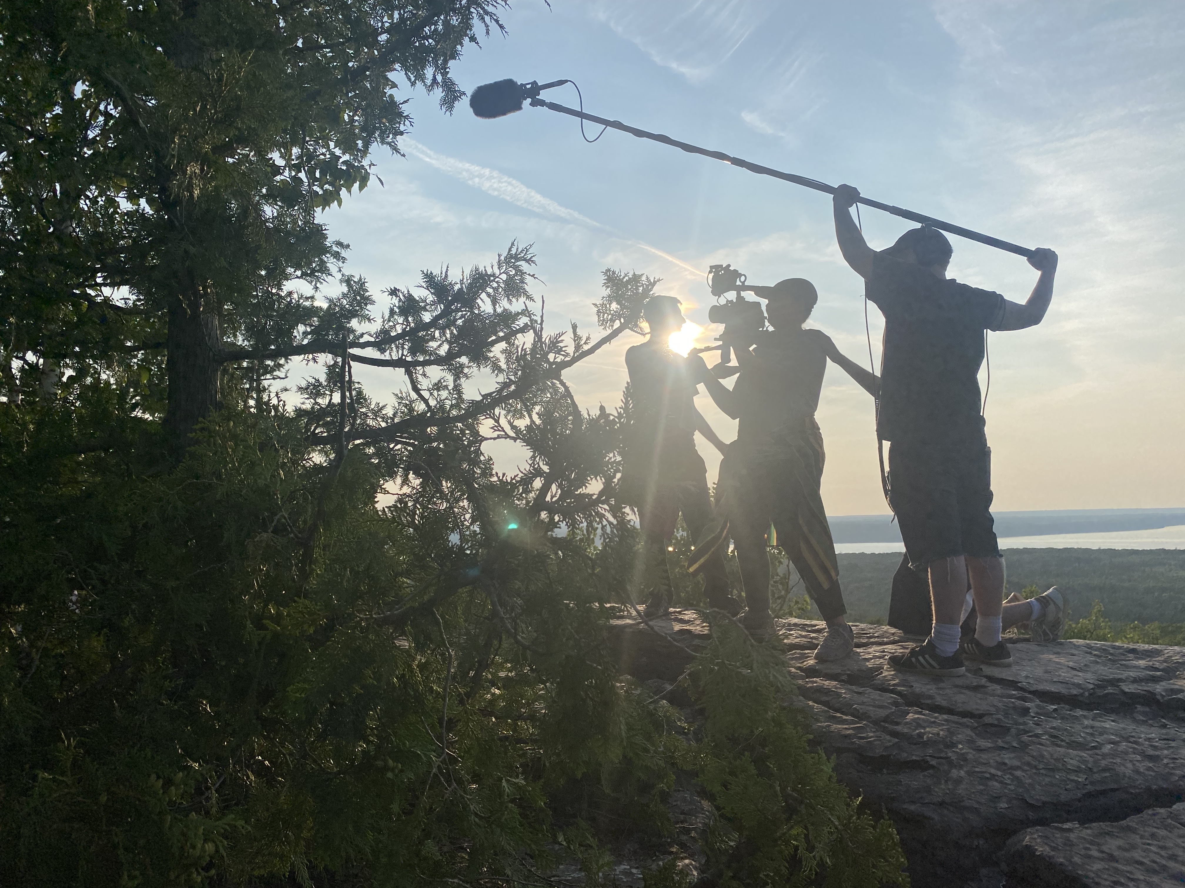 Film crew shooting at sunset on a rocky overlook