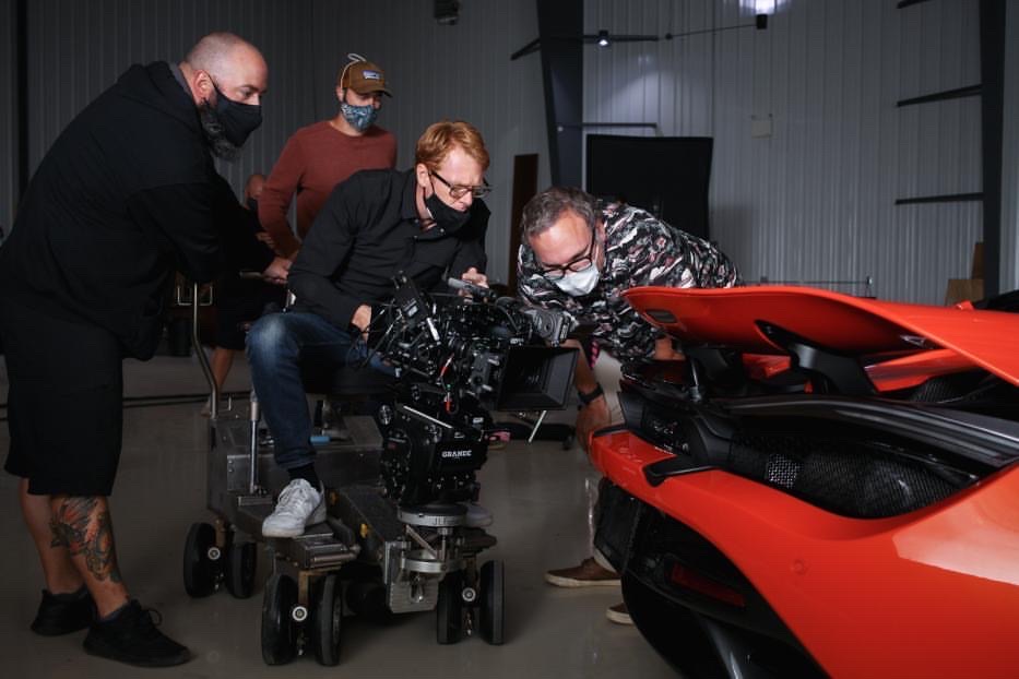 Camera crew filming a red car